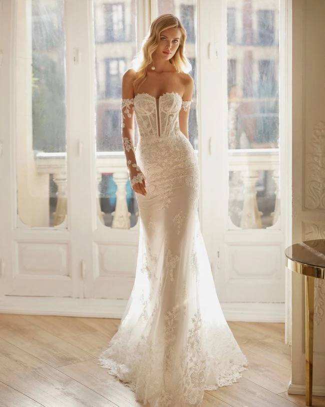 Model in shear wedding dress in front of window